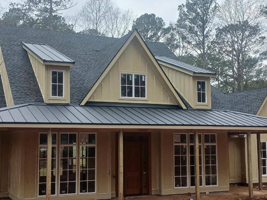Completed shingle roof with standing seam metal porch roof on a custom home