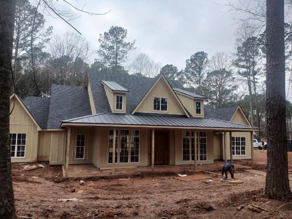 Finished custom home with shingle roof and standing seam metal porch roof