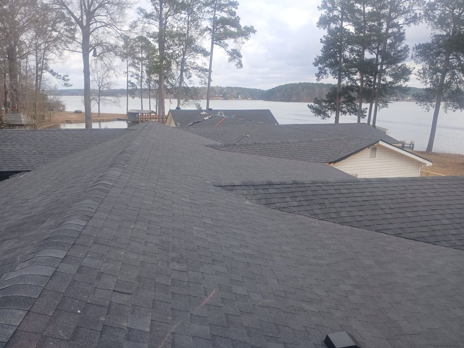Completed architectural shingle roof on a lake house overlooking the water