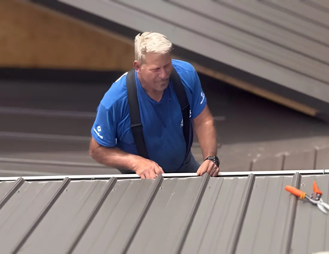 Mark Hobby, owner of Residential Concerns, setting trim on a brown metal roof